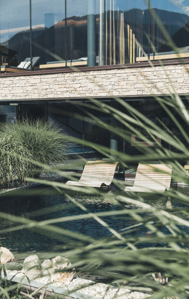 Doppelliegen aus Holz im Badeteich des Wellnesshotels Nesslerhof in Großarl, Salzburger Land