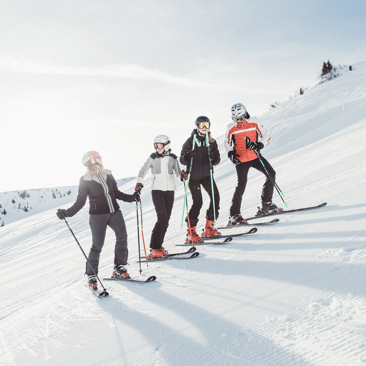 Eine Gruppe Skifahrer steht auf der Piste in der Skiregion Großarl, Salzburger Land.